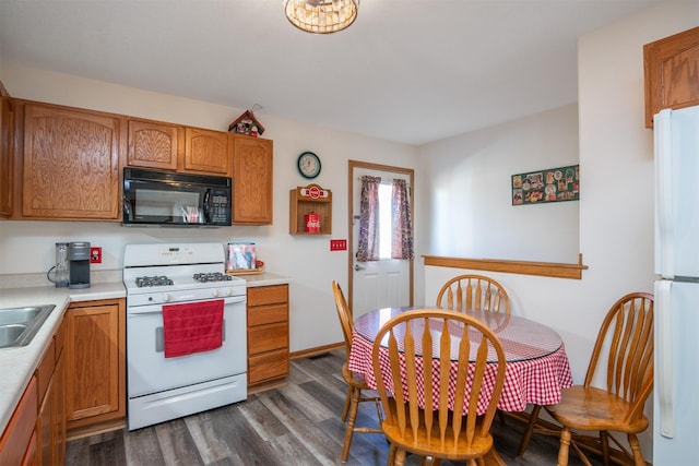 kitchen with white appliances, dark hardwood / wood-style floors, and sink