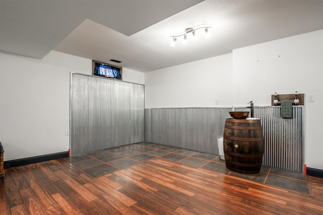 unfurnished room with dark wood-type flooring and wood walls