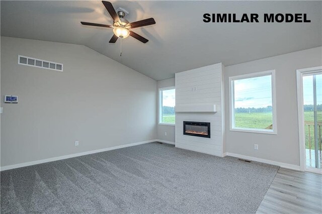 unfurnished living room featuring ceiling fan, lofted ceiling, a fireplace, and carpet