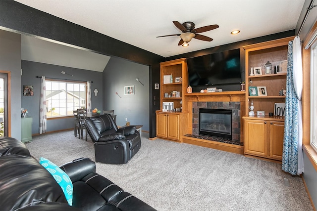 living room featuring light carpet, a fireplace, ceiling fan, and vaulted ceiling