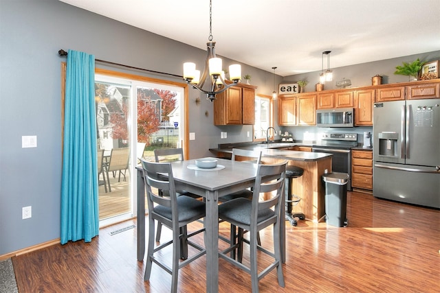 dining area with hardwood / wood-style flooring, a chandelier, and sink