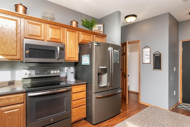 kitchen featuring dark wood-type flooring and appliances with stainless steel finishes