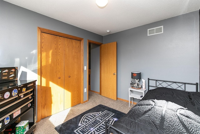 carpeted bedroom featuring a closet and a textured ceiling