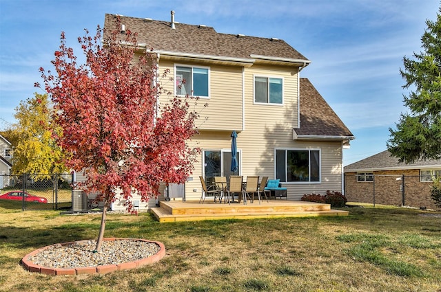 rear view of house featuring a wooden deck and a yard