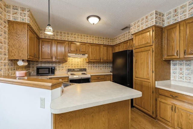 kitchen featuring black appliances, hanging light fixtures, kitchen peninsula, a textured ceiling, and light wood-type flooring