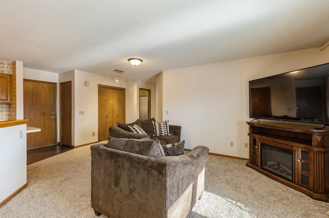 carpeted living room featuring a textured ceiling