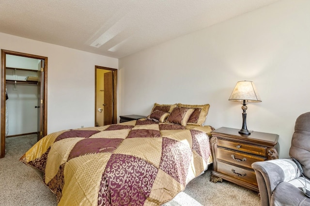 carpeted bedroom with a spacious closet, a closet, and a textured ceiling