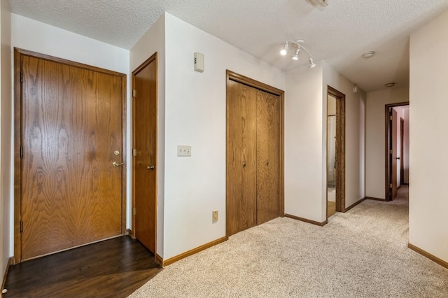 hall with carpet floors and a textured ceiling