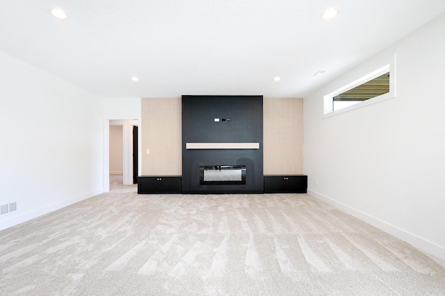 unfurnished living room featuring recessed lighting, a large fireplace, carpet flooring, and baseboards