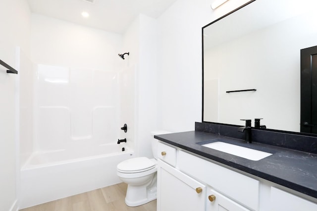 bathroom featuring vanity,  shower combination, wood finished floors, and toilet