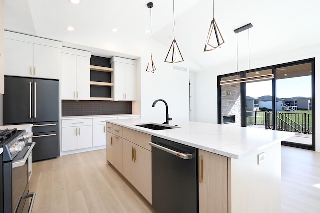 kitchen with sink, white cabinetry, hanging light fixtures, appliances with stainless steel finishes, and an island with sink