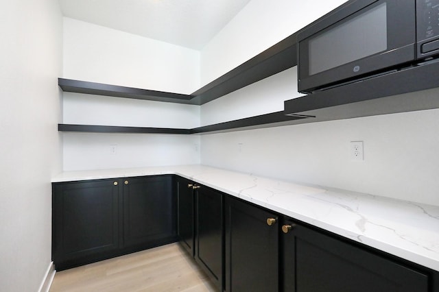 interior space with black microwave and light wood-type flooring