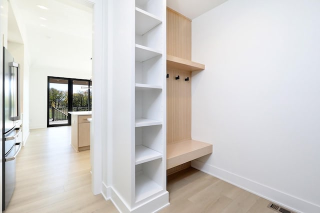 mudroom featuring light wood-type flooring, visible vents, and baseboards