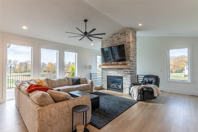 living area with recessed lighting, a large fireplace, wood finished floors, baseboards, and vaulted ceiling