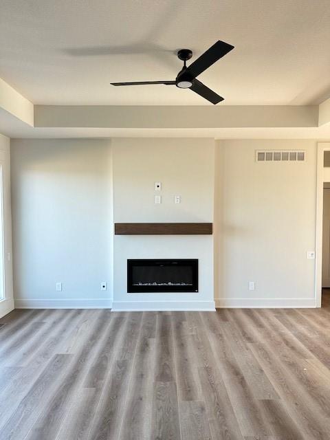 unfurnished living room with hardwood / wood-style floors and ceiling fan