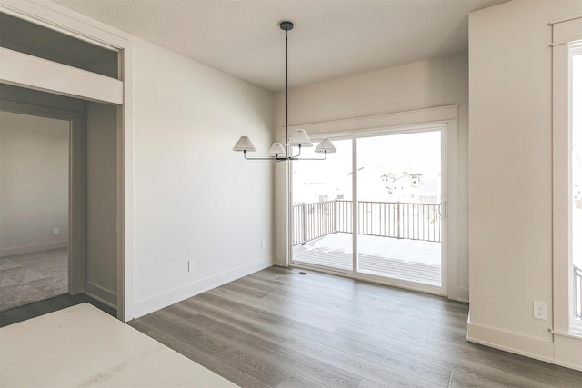 unfurnished dining area with dark hardwood / wood-style floors and a notable chandelier