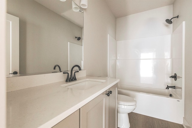 full bathroom featuring toilet, hardwood / wood-style flooring, vanity, and washtub / shower combination