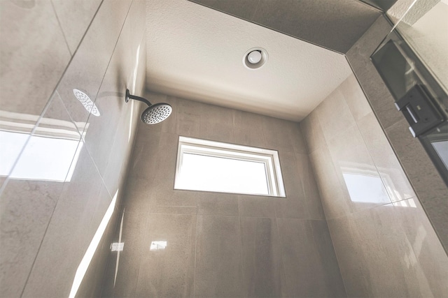 bathroom with a shower and a textured ceiling