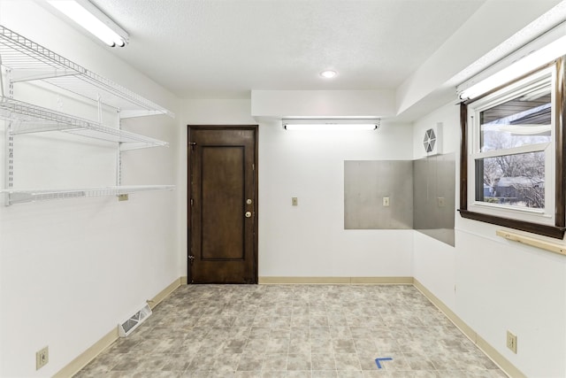 unfurnished room with a textured ceiling