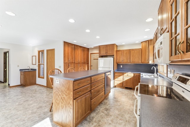 kitchen featuring white appliances, a center island, and sink