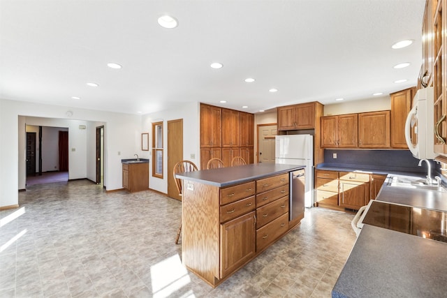 kitchen with a center island, sink, and white appliances