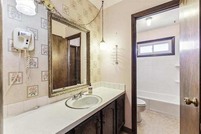 full bathroom with vanity, tiled shower / bath, tile patterned flooring, and toilet