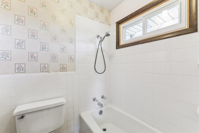 bathroom featuring tile walls, tiled shower / bath, and toilet