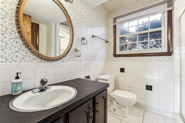 bathroom featuring tile patterned flooring, vanity, tile walls, and toilet