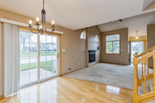 unfurnished living room with an inviting chandelier and hardwood / wood-style flooring