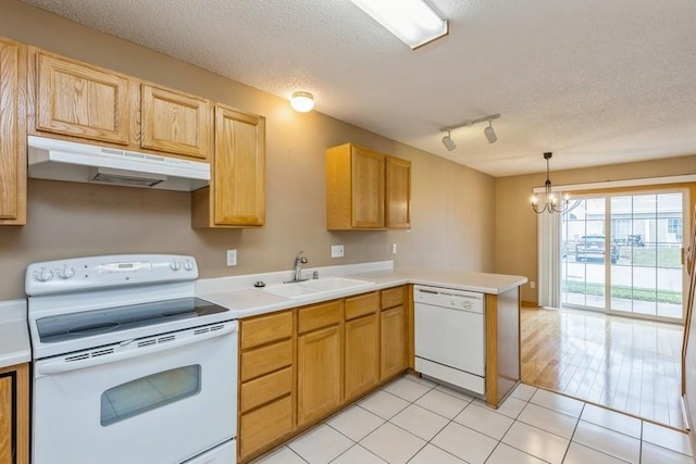 kitchen with light tile patterned flooring, sink, kitchen peninsula, pendant lighting, and white appliances