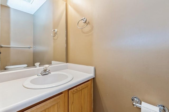 bathroom with vanity, a skylight, and toilet