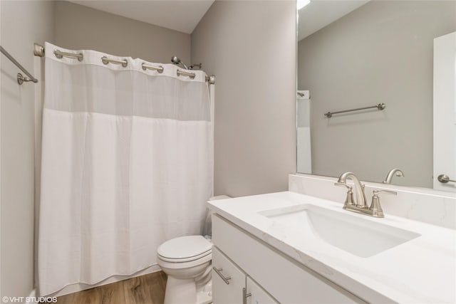 bathroom featuring wood-type flooring, toilet, and vanity