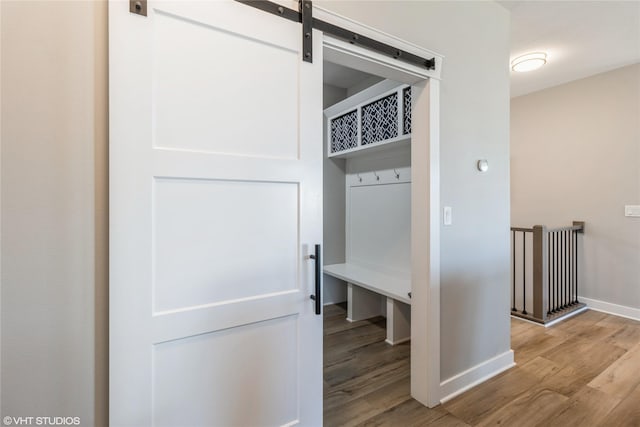 mudroom featuring a barn door and light wood-type flooring