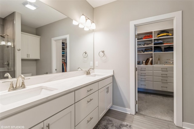 bathroom featuring vanity, wood-type flooring, toilet, and walk in shower