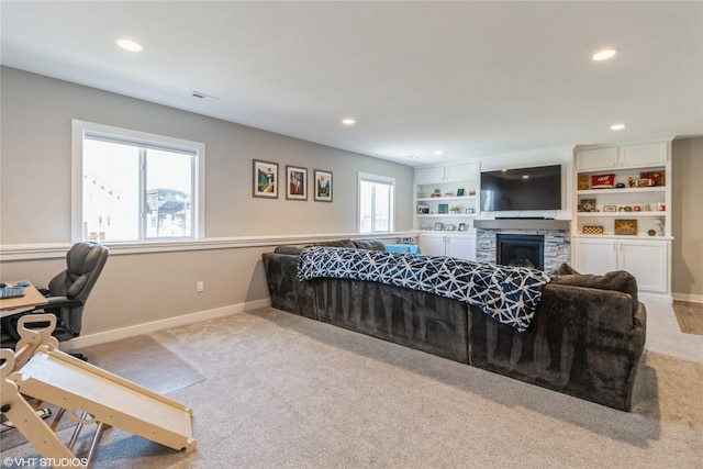 carpeted bedroom featuring a stone fireplace