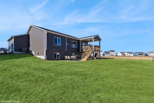 back of house featuring central AC unit, a yard, and a deck