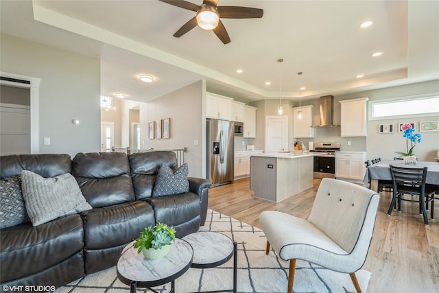 1210 NW Pine Bluff Cir, Waukee, IA 50263 - living area with a tray ceiling, ceiling fan, light wood-type flooring, and recessed lighting
