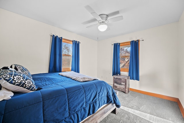 carpeted bedroom featuring multiple windows and ceiling fan