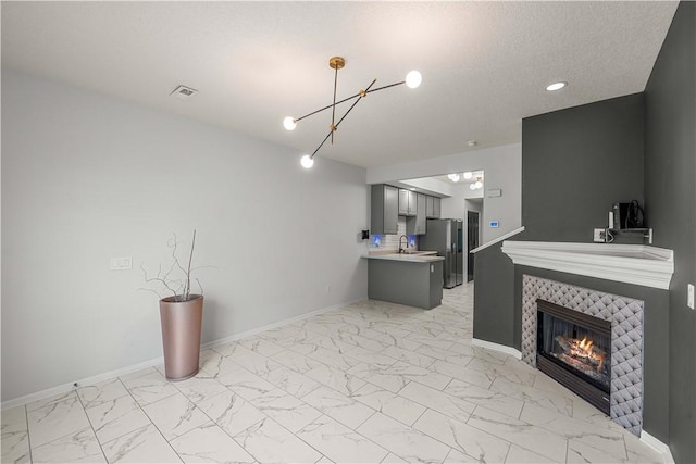 interior space featuring sink, a notable chandelier, and a fireplace