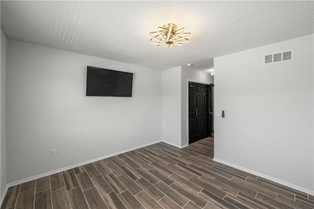 empty room featuring dark hardwood / wood-style flooring and a textured ceiling