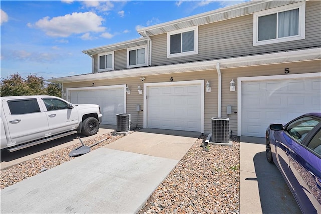 view of front of property featuring a garage and central air condition unit