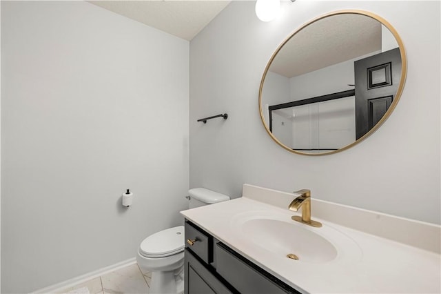 bathroom with tile patterned flooring, vanity, and toilet