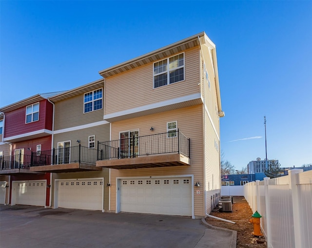 rear view of property featuring a garage and central AC unit