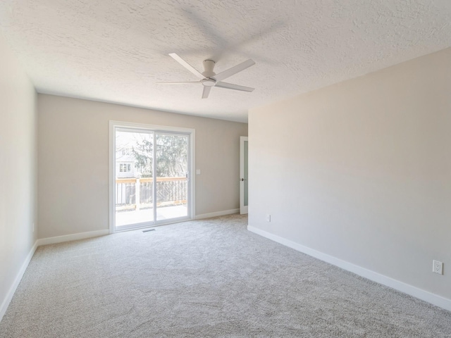 empty room with ceiling fan, carpet, and a textured ceiling