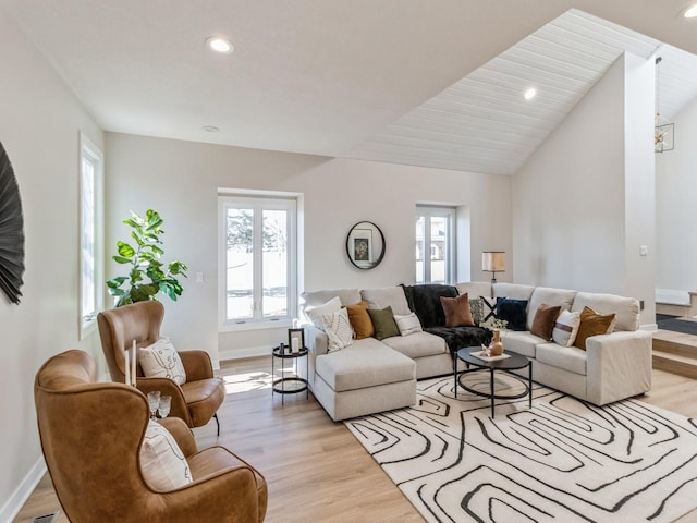 living room featuring lofted ceiling and light hardwood / wood-style flooring