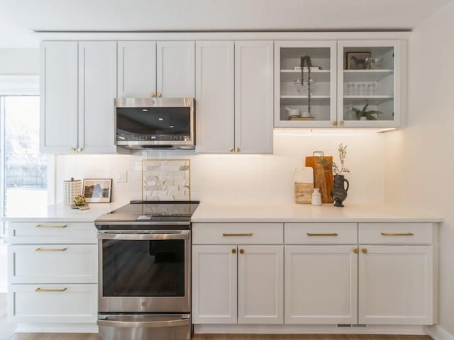 kitchen with appliances with stainless steel finishes, decorative backsplash, and white cabinets