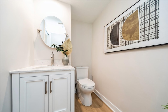 bathroom featuring vanity, wood-type flooring, and toilet