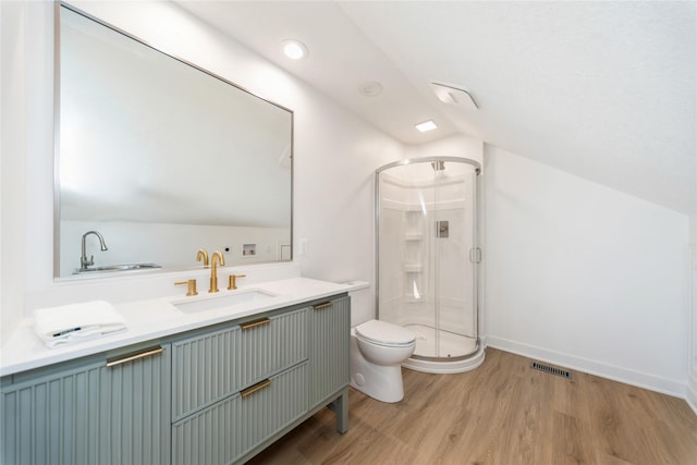 bathroom featuring toilet, an enclosed shower, vaulted ceiling, vanity, and hardwood / wood-style floors