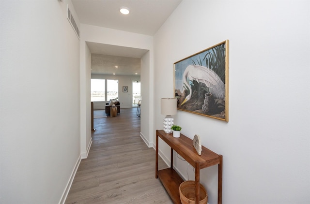 hallway with recessed lighting, baseboards, visible vents, and light wood finished floors