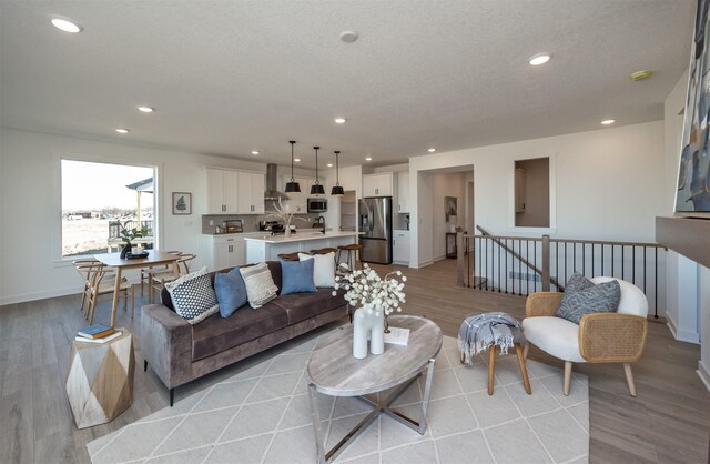 living room with light hardwood / wood-style floors and a textured ceiling